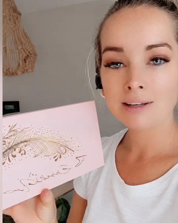 Marian showing her pink hot-stamp box with a gold feather logo